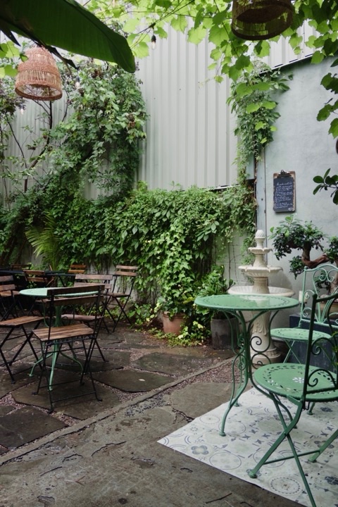 A leafy café courtyard with bistro tables